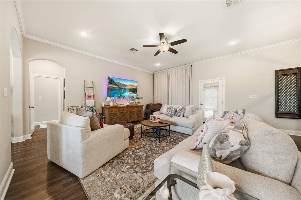 386 Cavitt Court, Robinson, TX 76706 Living area featuring wood-finish flooring, an arched doorway, crown molding, a ceiling fan with integrated lighting, and recessed lighting