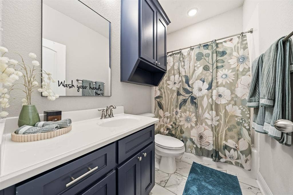386 Cavitt Court, Robinson, TX 76706 Bathroom featuring a vanity with dark blue cabinetry, a white countertop, and a rectangular mirror