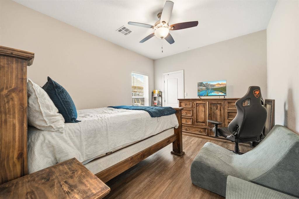 386 Cavitt Court, Robinson, TX 76706 Bedroom featuring wood-finish flooring, a vaulted ceiling, a ceiling fan with integrated lighting, and a window with horizontal blinds