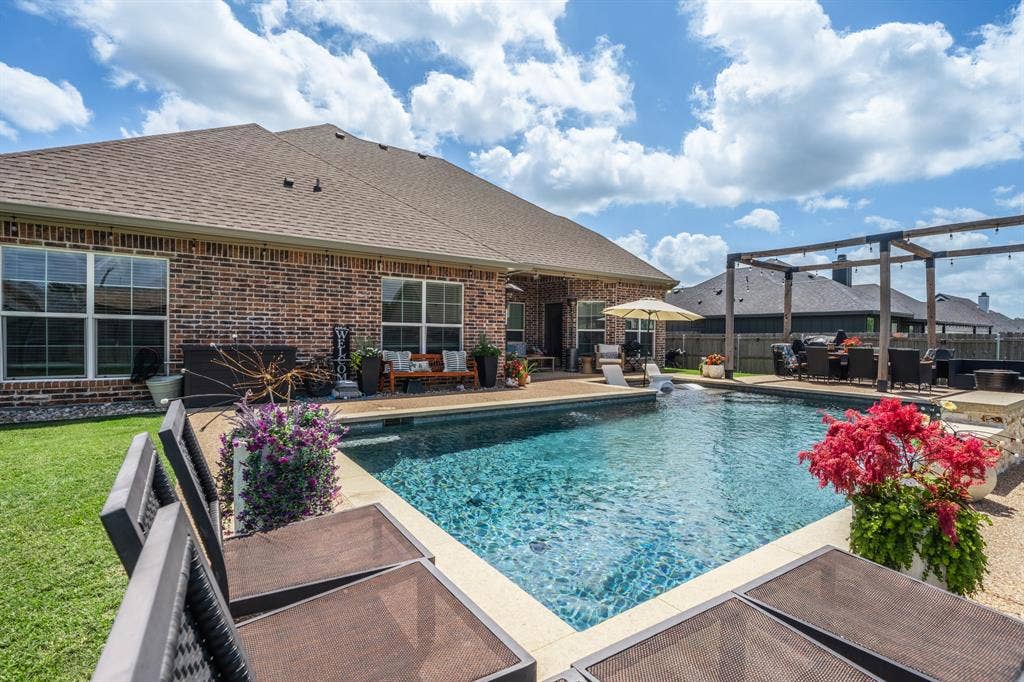 386 Cavitt Court, Robinson, TX 76706 Spacious backyard featuring a rectangular swimming pool with surrounding patio, a brick exterior, and a large pergola structure