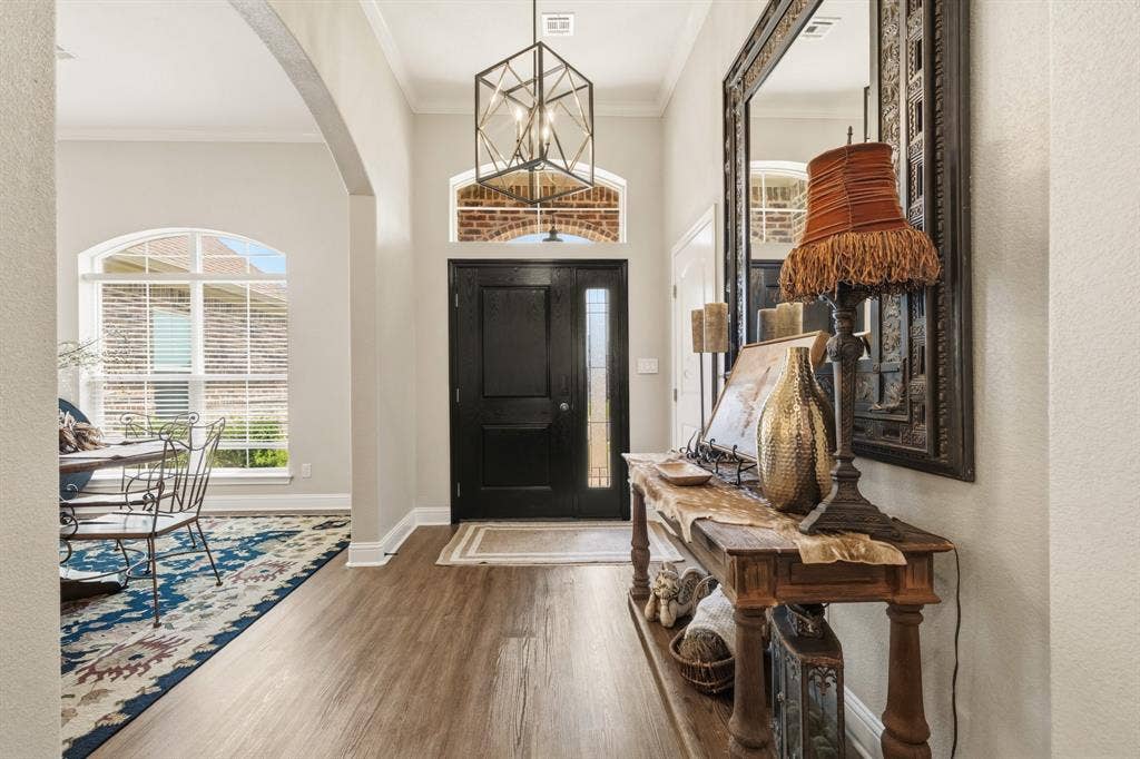 386 Cavitt Court, Robinson, TX 76706 Welcoming entryway featuring a dark-paneled door with sidelight, transom window, and a geometric pendant light fixture