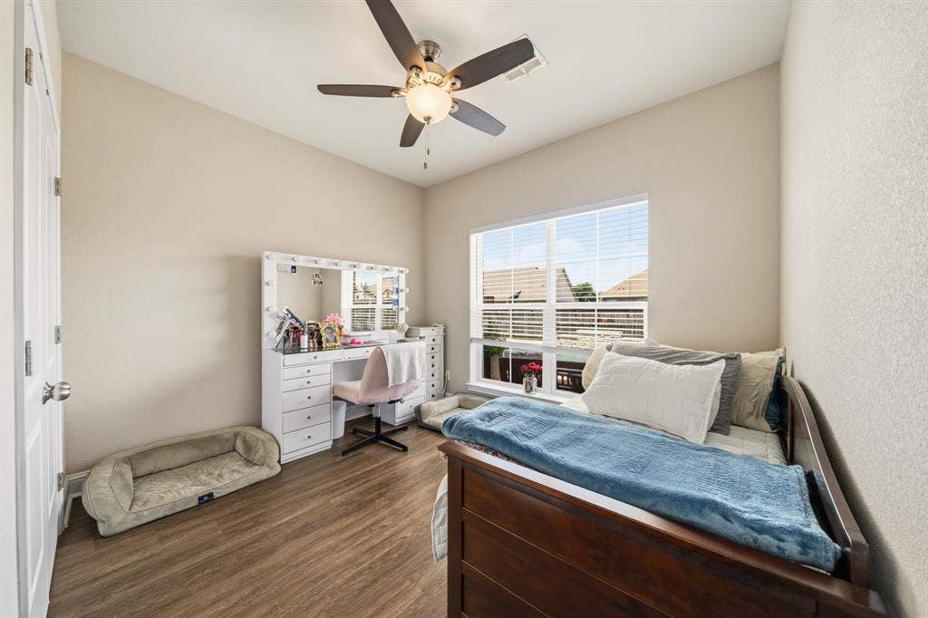 386 Cavitt Court, Robinson, TX 76706 Bright interior room featuring wood-finish flooring, a large window with blinds, and a ceiling fan with integrated lighting
