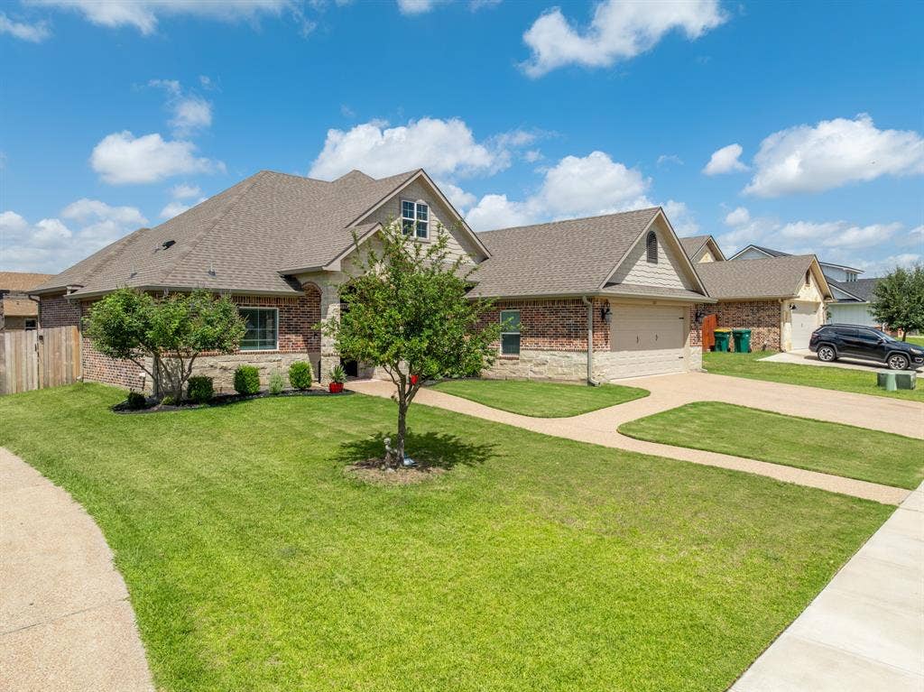 386 Cavitt Court, Robinson, TX 76706 Brick and stone facade residence featuring a peaked roofline, gabled dormer, and an attached two-car garage