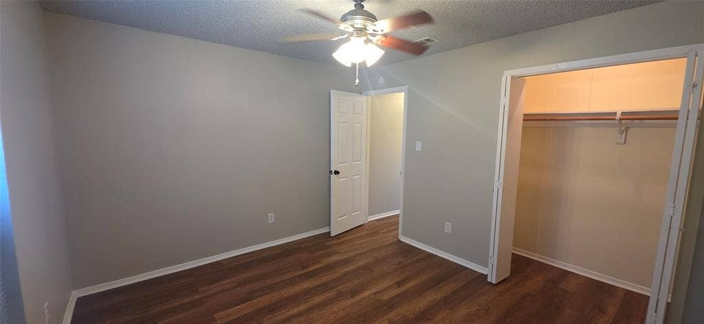 235 Vista Way, Benbrook, TX 76126 Room featuring wood-finish flooring, a ceiling fan with integrated lighting, and a closet with a built-in rod