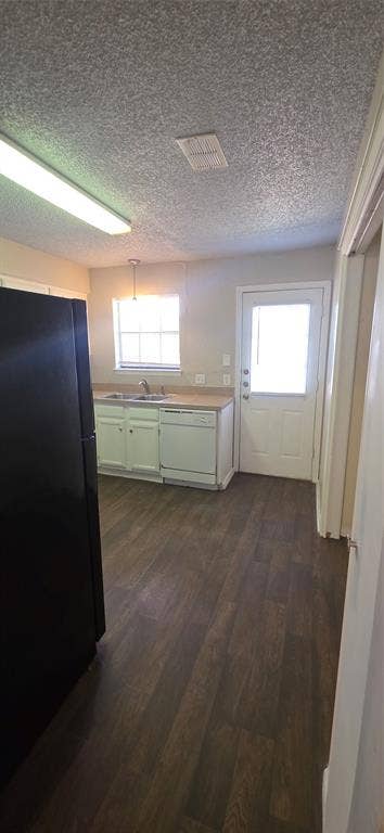 235 Vista Way, Benbrook, TX 76126 Kitchen featuring wood-finish flooring, white cabinetry, a single basin sink, and a full-light exterior door