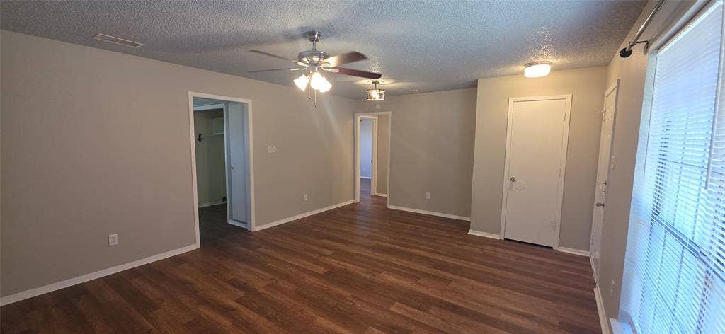 235 Vista Way, Benbrook, TX 76126 Spacious room with wood-finish flooring, neutral paint, and ceiling fans