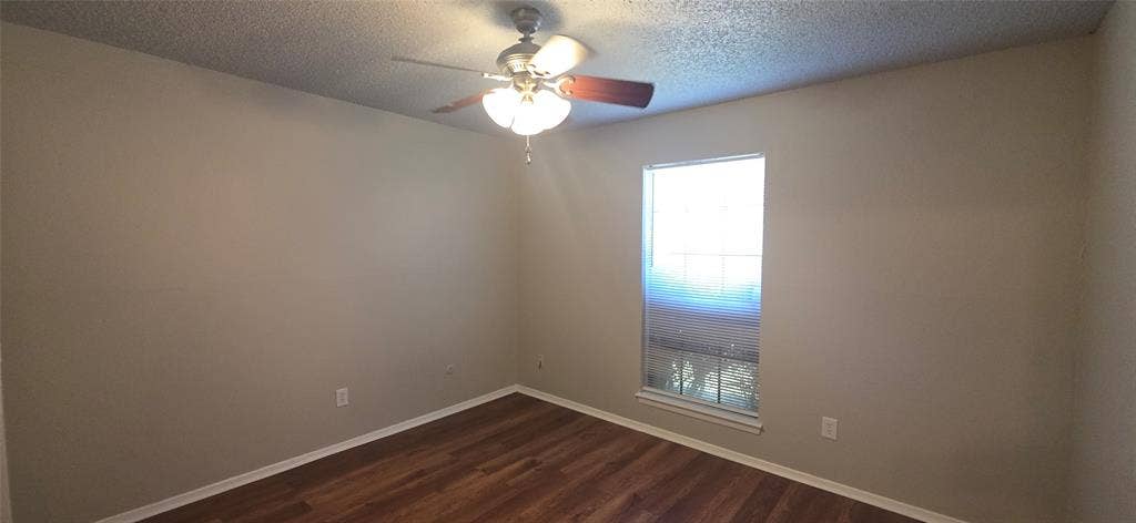 235 Vista Way, Benbrook, TX 76126 Wood-finish flooring, neutral wall tones, ceiling fan with integrated lighting, and a window providing natural illumination