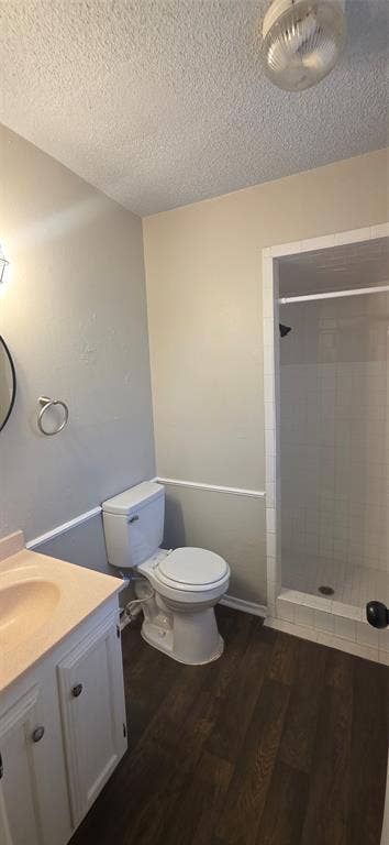 235 Vista Way, Benbrook, TX 76126 Bathroom featuring wood-finish flooring, white vanity with integrated sink, toilet, and a glass-enclosed shower