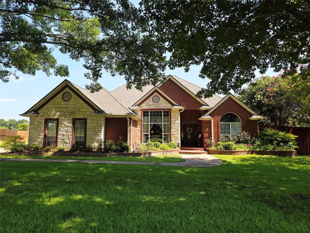 126 E Post Oak, Frankston, TX 75763 Brick and stone facade residence featuring multiple gables and a large front lawn