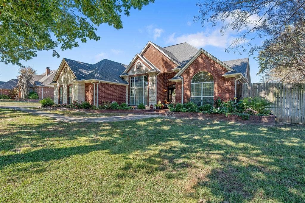 126 E Post Oak, Frankston, TX 75763 Brick and siding exterior featuring a prominent arched window and multiple gables