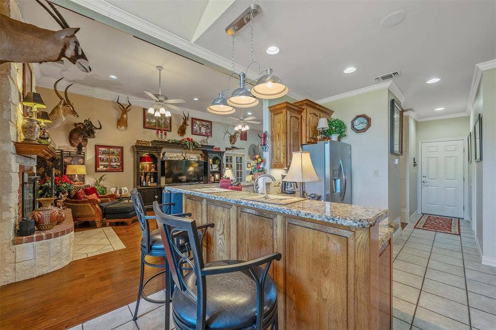 126 E Post Oak, Frankston, TX 75763 Kitchen island with granite countertop and wood-finish cabinetry
