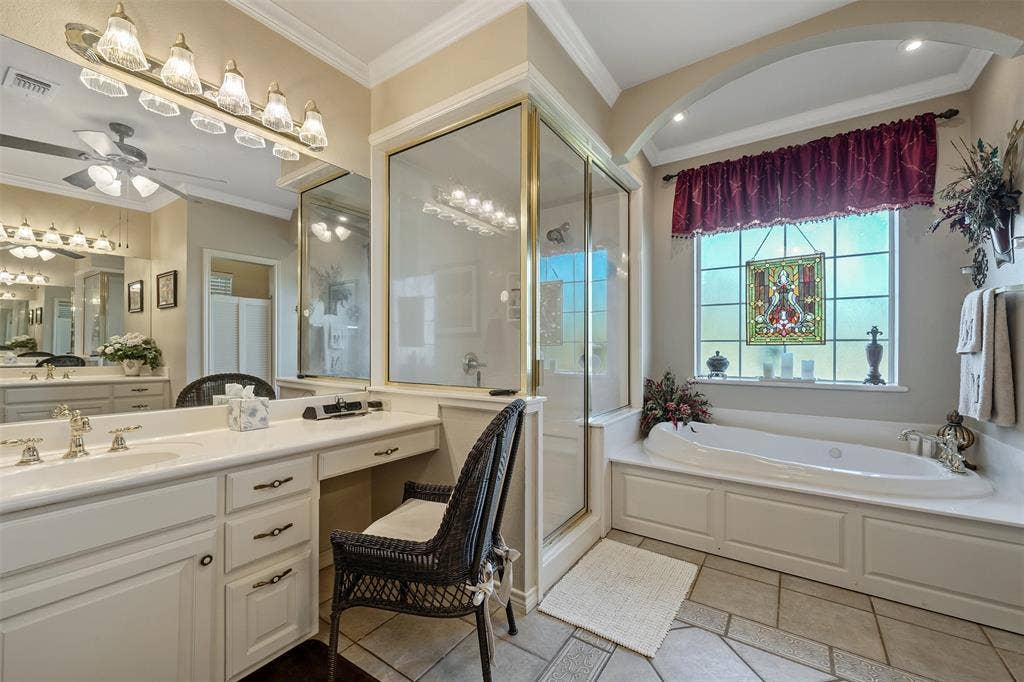126 E Post Oak, Frankston, TX 75763 Spacious bathroom featuring a built-in soaking tub, a separate glass-enclosed shower, and a dual-sink vanity with an integrated makeup area