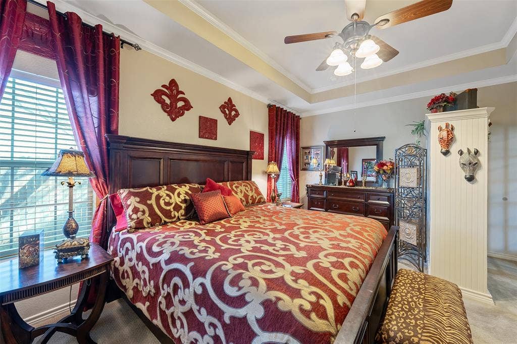 126 E Post Oak, Frankston, TX 75763 Spacious bedroom featuring a tray ceiling with crown molding, ceiling fan, and large windows with blinds
