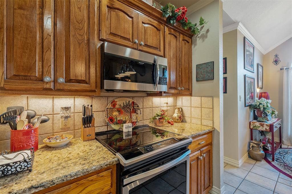 126 E Post Oak, Frankston, TX 75763 Kitchen featuring wood cabinetry, stainless steel microwave, and a black electric range