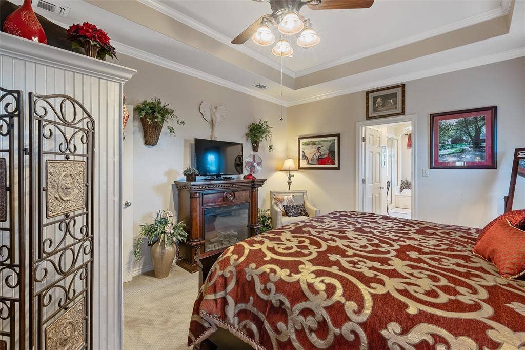 126 E Post Oak, Frankston, TX 75763 Bedroom featuring tray ceiling, crown molding, ceiling fan with light fixture, and carpet flooring
