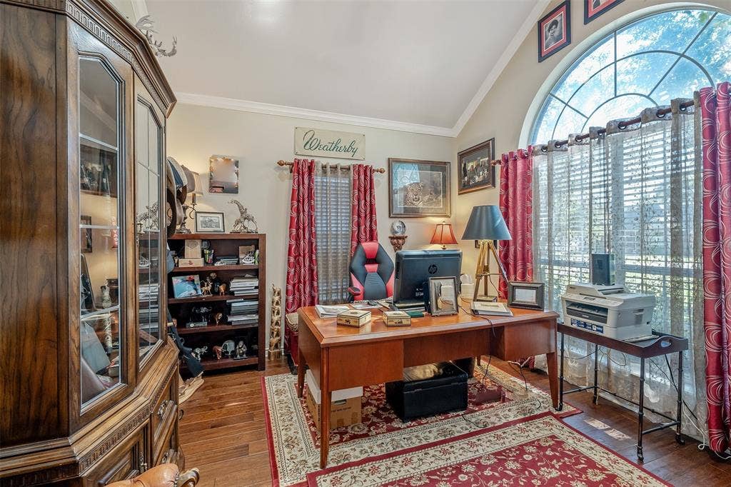 126 E Post Oak, Frankston, TX 75763 Room featuring a large arched window with decorative mullions, wood-finish flooring, and crown molding