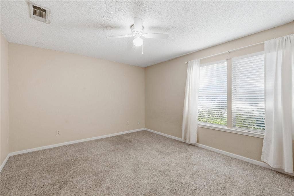 6505 Hughes Drive, Watauga, TX 76148 Carpeted room featuring neutral wall tones and a textured ceiling