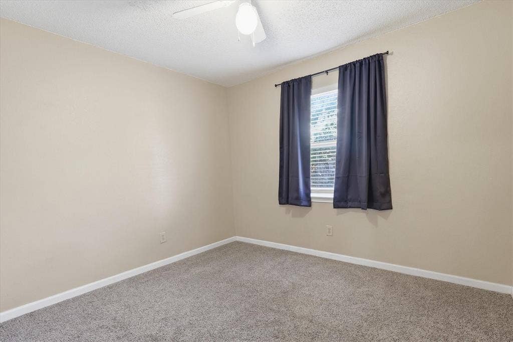 6505 Hughes Drive, Watauga, TX 76148 Room featuring neutral-toned walls, textured ceiling, and gray carpeting