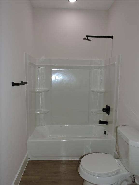 163 Lake Creek Drive, Mabank, TX 75156 Bathroom featuring a white tub/shower combination with black fixtures, a white toilet, recessed lighting, and wood-finish flooring