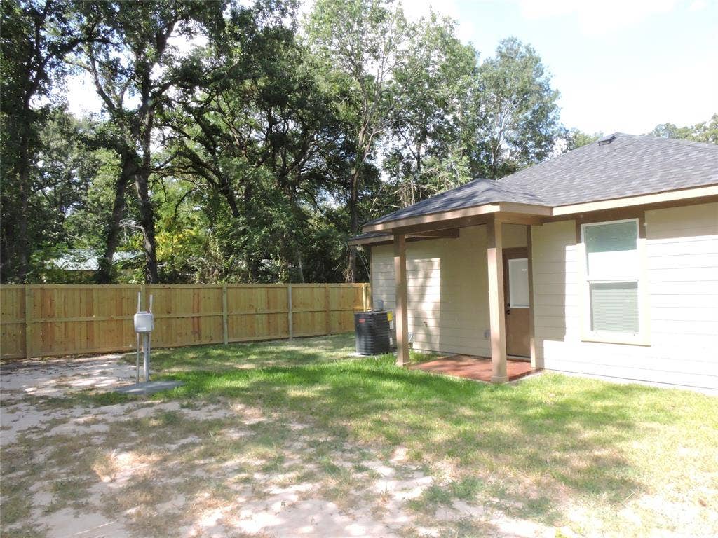 163 Lake Creek Drive, Mabank, TX 75156 Private backyard with a new wood privacy fence, a covered patio, and mature perimeter trees