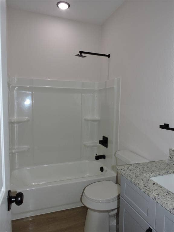 163 Lake Creek Drive, Mabank, TX 75156 Full bathroom featuring a white tub/shower combination with matte black fixtures, a white toilet, and wood-finish flooring