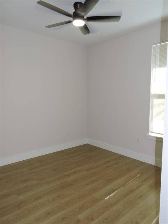 163 Lake Creek Drive, Mabank, TX 75156 Interior room featuring wood-finish flooring, white baseboards, a window with blinds, and an overhead ceiling fan with integrated lighting