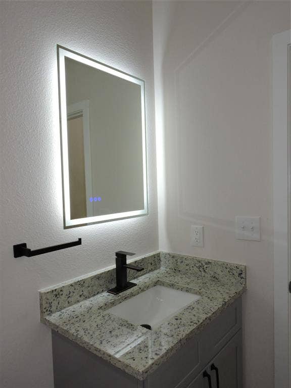 163 Lake Creek Drive, Mabank, TX 75156 Bathroom vanity featuring a granite countertop, integrated sink, and matte black faucet