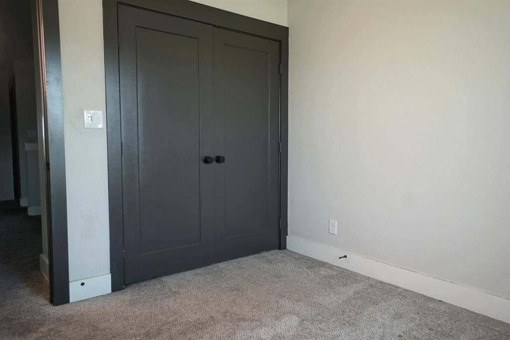 1764 Palladio Loop, Princeton, TX 75407 Gray paneled bi-fold closet doors with round black hardware, light gray walls, and light gray carpeting