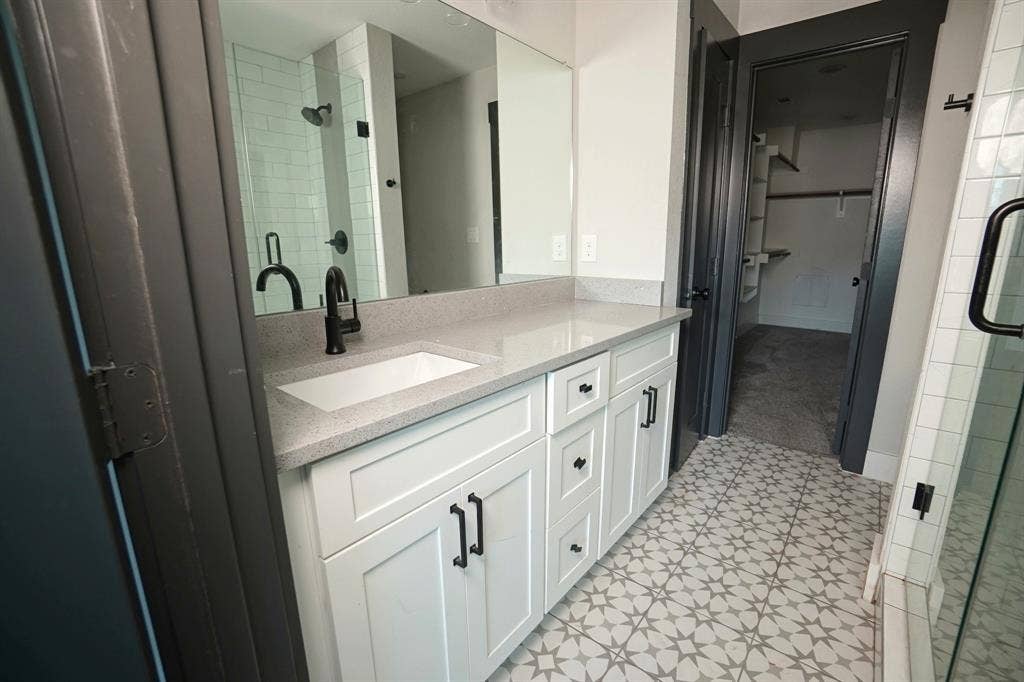 1764 Palladio Loop, Princeton, TX 75407 Vanity with white shaker cabinetry, light-toned countertop, and matte black hardware
