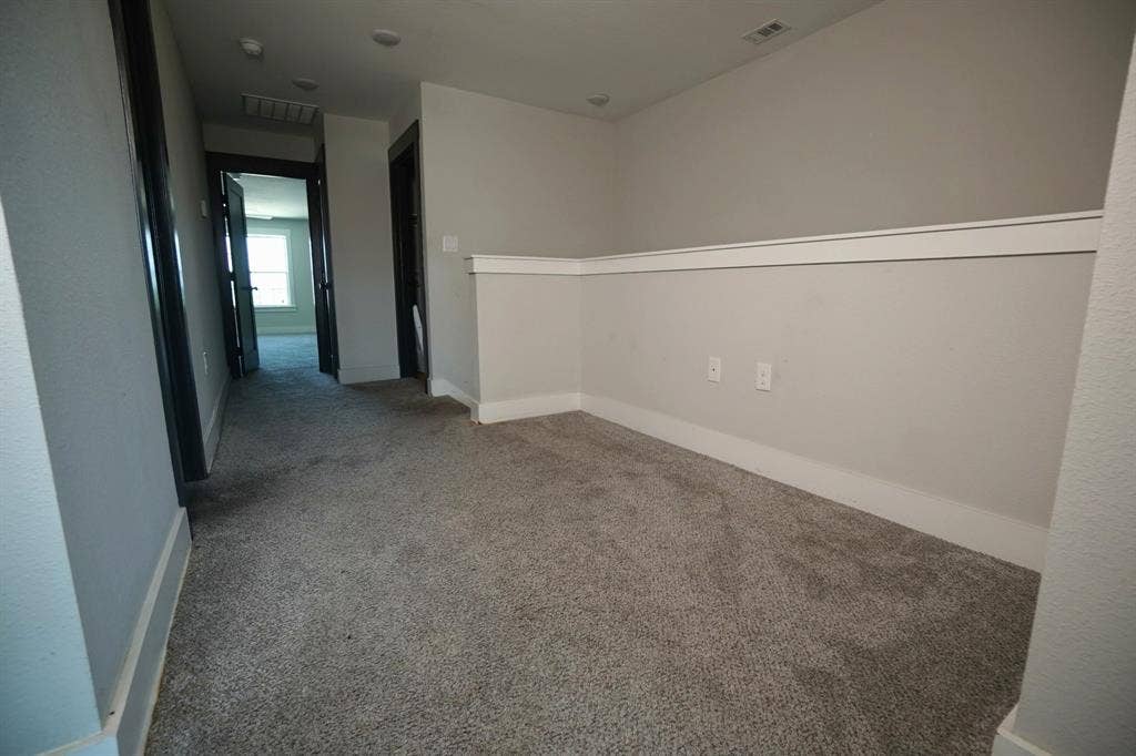 1764 Palladio Loop, Princeton, TX 75407 Carpeted hallway featuring light gray walls, white chair rail molding, and dark trim around doorways