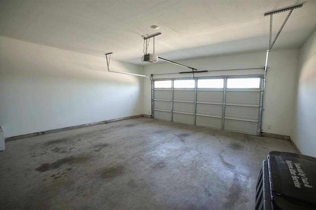 1764 Palladio Loop, Princeton, TX 75407 Two-car garage with a sectional garage door featuring upper-level windows, an automatic opener, and painted walls