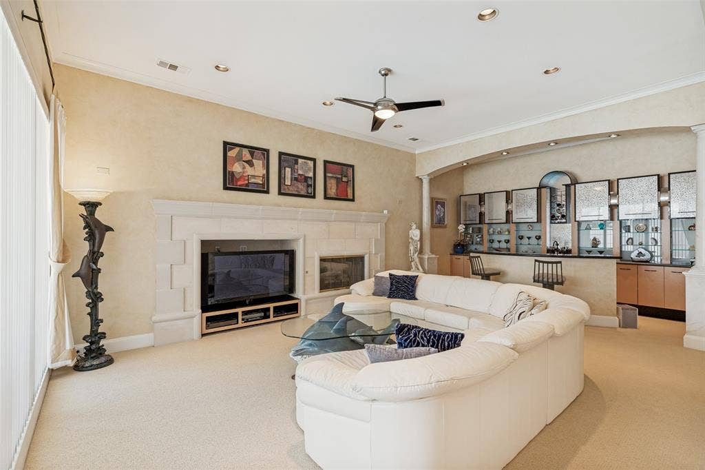 5920 Mcfarland Drive, Plano, TX 75093 Spacious living area featuring a built-in entertainment center with a stone fireplace, recessed lighting, and a ceiling fan