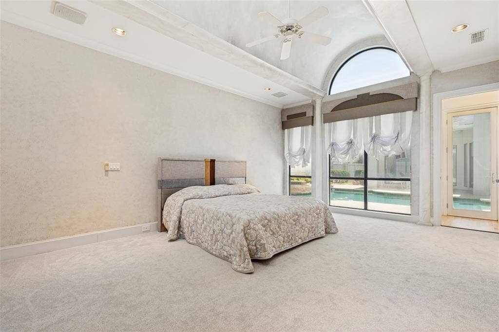 5920 Mcfarland Drive, Plano, TX 75093 Arched window overlooking a pool, featuring floor-to-ceiling glass, a glass-paneled door, and recessed lighting