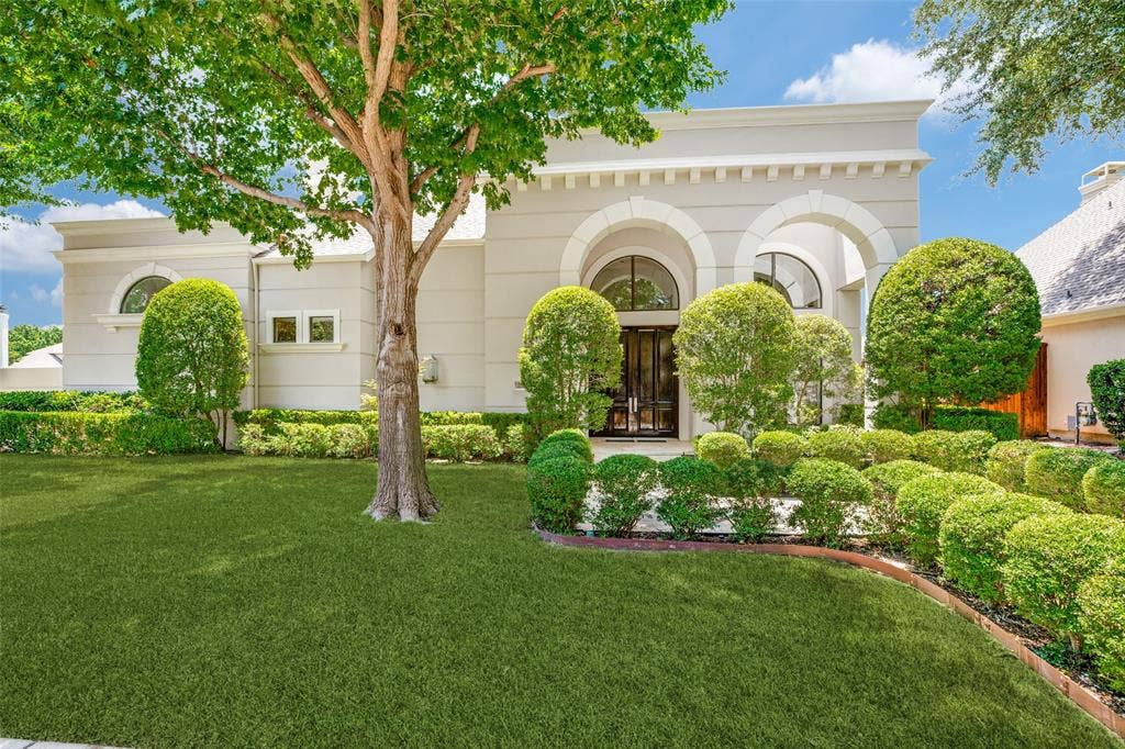 5920 Mcfarland Drive, Plano, TX 75093 Stucco exterior with arched entryways, dark double doors, and a decorative architectural facade