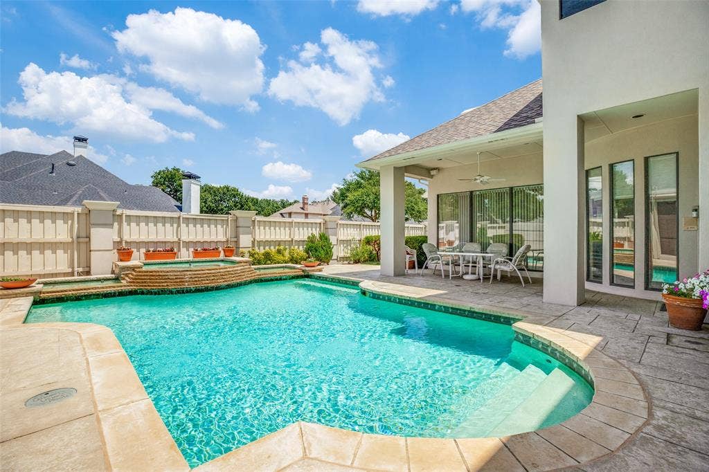 5920 Mcfarland Drive, Plano, TX 75093 Expansive outdoor living area featuring a swimming pool with integrated spa and stone coping