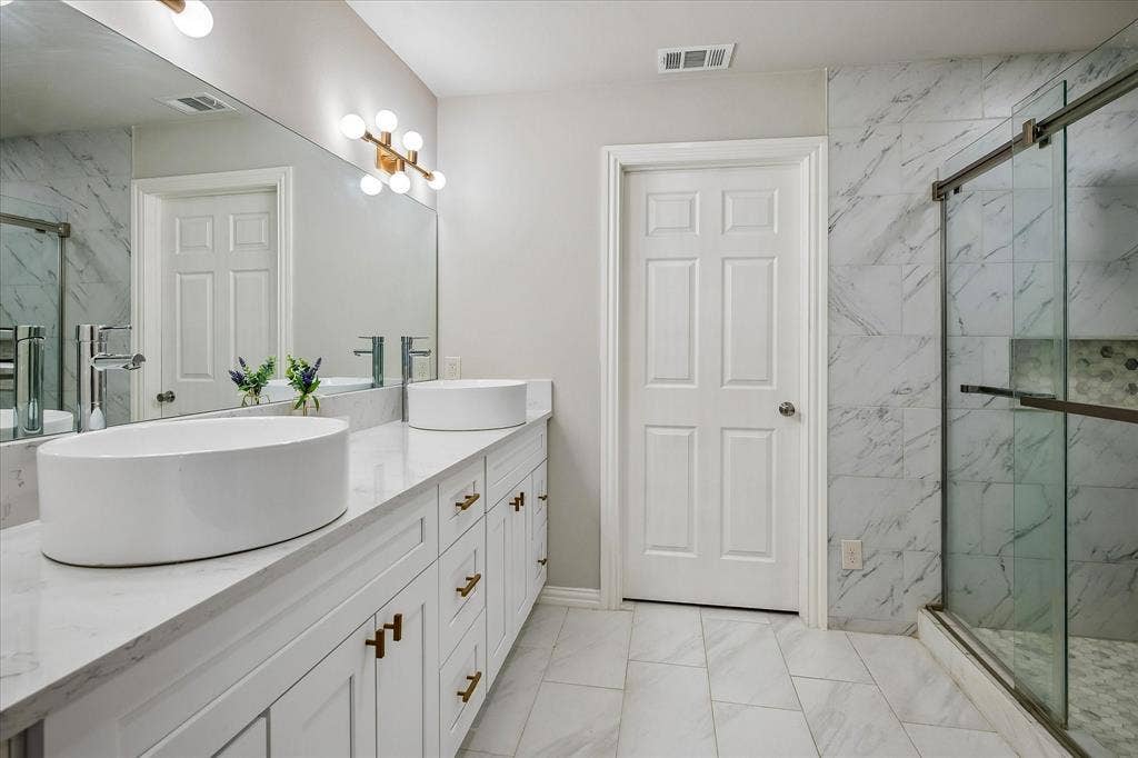 The Primary Bathroom, Ensuite, on the 1st level has been completely remodeled and has heated floors,  dual sinks, an oversized shower and a huge walk-in closet.