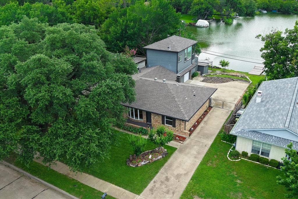 View of front of home, driveway, and view of lake.
