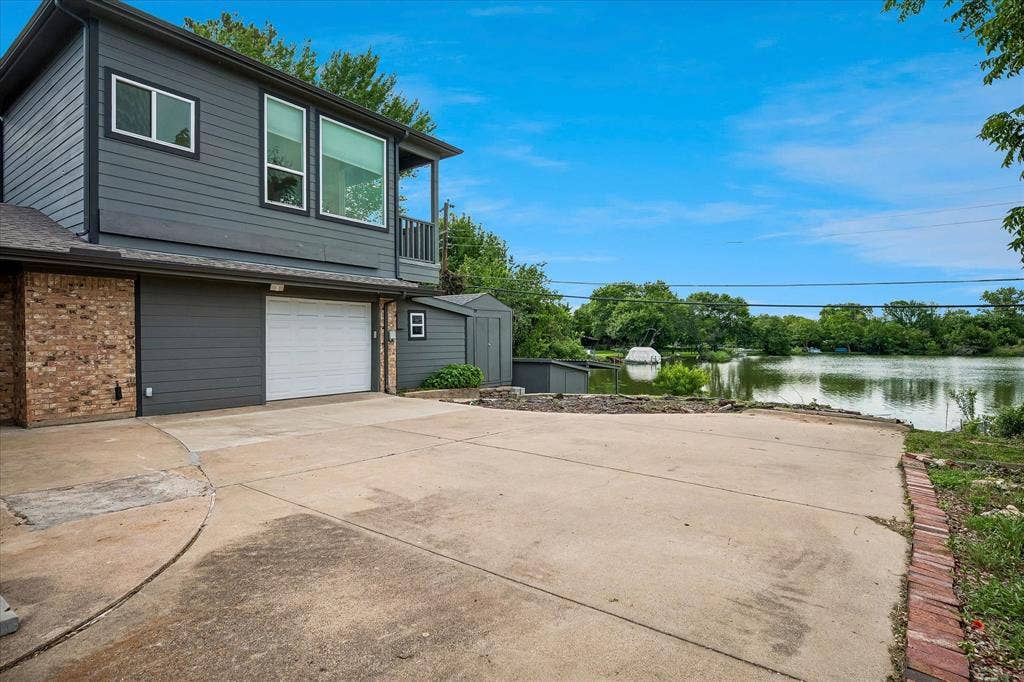 View of side entry garage, attached workshop, and view of lake in the background.