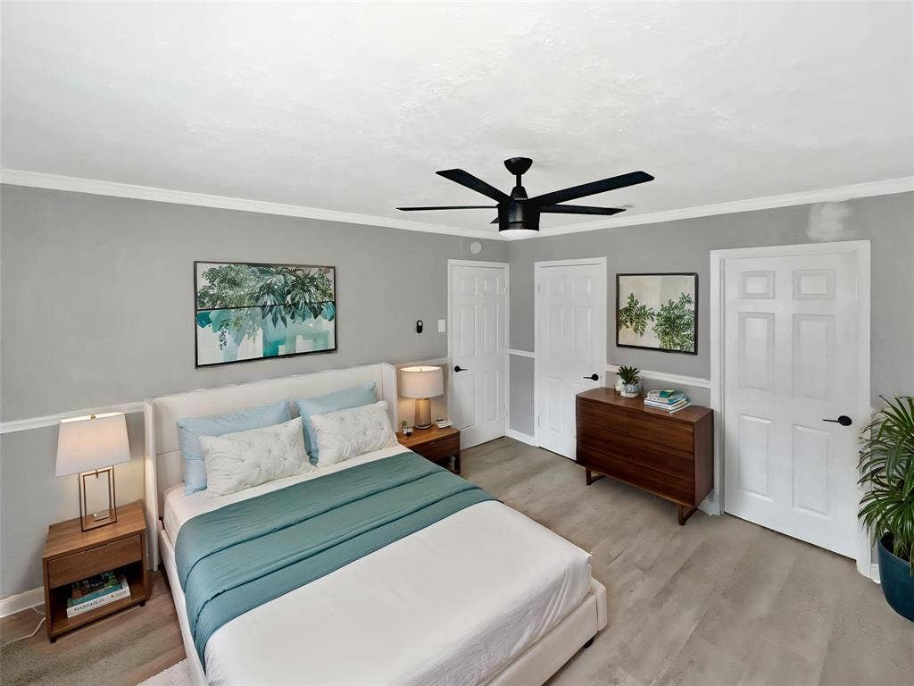 1306 Elby Street, Irving, TX 75061 Virtually stagedBedroom featuring a matte black ceiling fan, crown molding, light gray walls with wainscoting, and wood-finish flooring