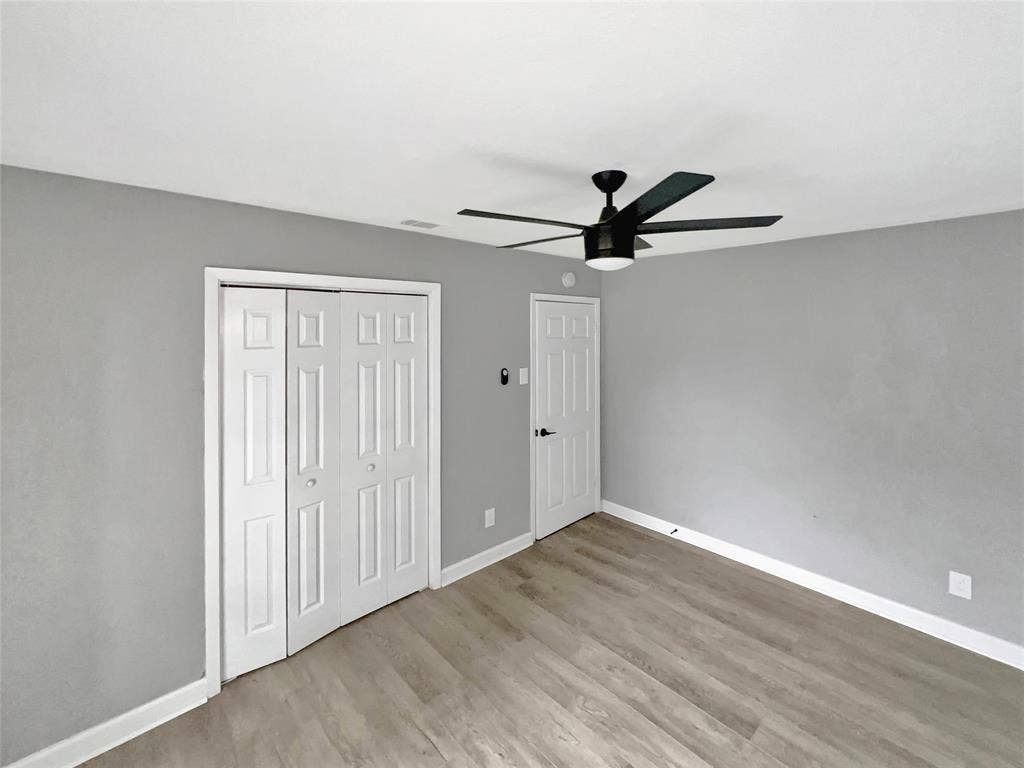 1306 Elby Street, Irving, TX 75061 Room featuring light wood-finish flooring, light gray wall paint, and white baseboards