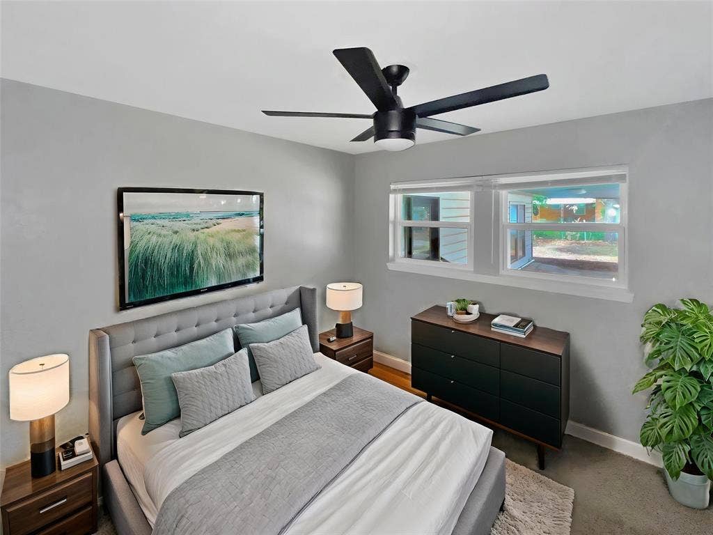 1306 Elby Street, Irving, TX 75061 Virtually stagedBedroom featuring a modern ceiling fan, two windows, and light gray wall paint
