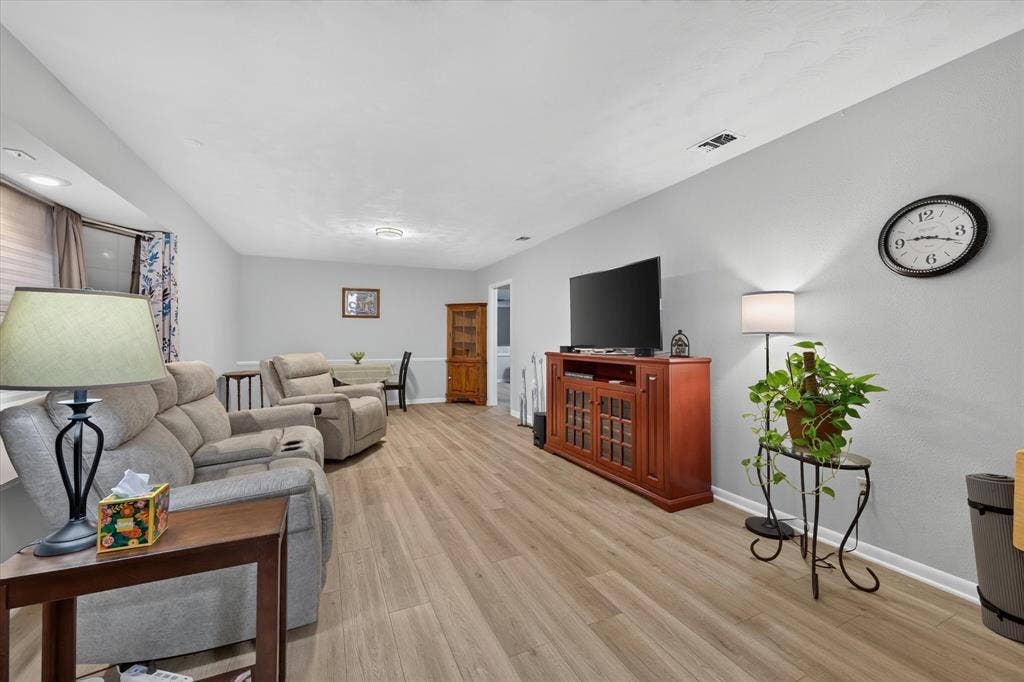 9700 Brookwood Circle, Woodway, TX 76712 Spacious room with wood-finish flooring, light grey wall paint, recessed lighting, and white baseboards