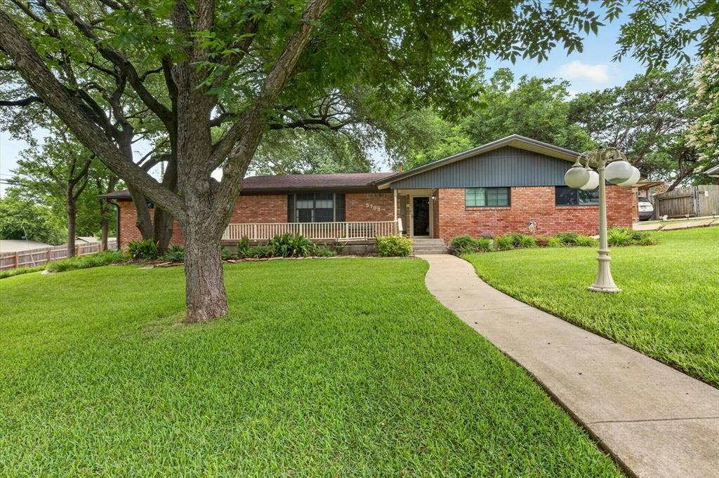 9700 Brookwood Circle, Woodway, TX 76712 Brick-clad exterior with a prominent front walkway and lush green lawn