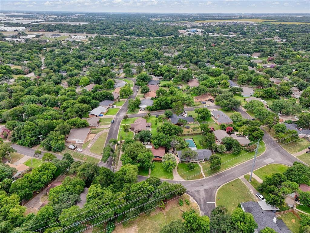9700 Brookwood Circle, Woodway, TX 76712 Expansive aerial perspective showcasing a residential neighborhood with abundant mature tree cover and curving street layouts