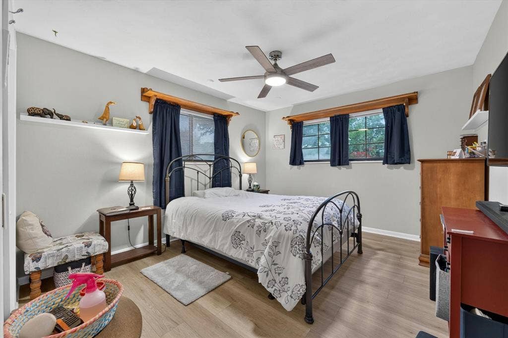 9700 Brookwood Circle, Woodway, TX 76712 Spacious room with light wood-finish flooring, a ceiling fan with integrated lighting, and multiple windows