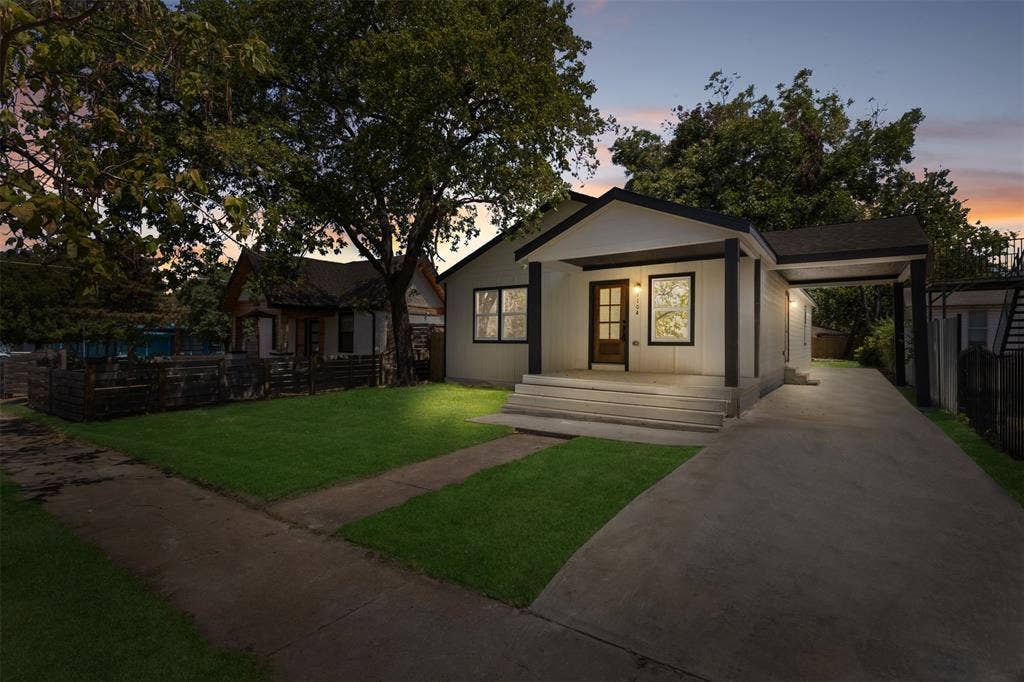1104 S Brighton Avenue, Dallas, TX 75208 Contemporary single-story residence with a covered entryway, attached carport, concrete driveway, and manicured front lawn
