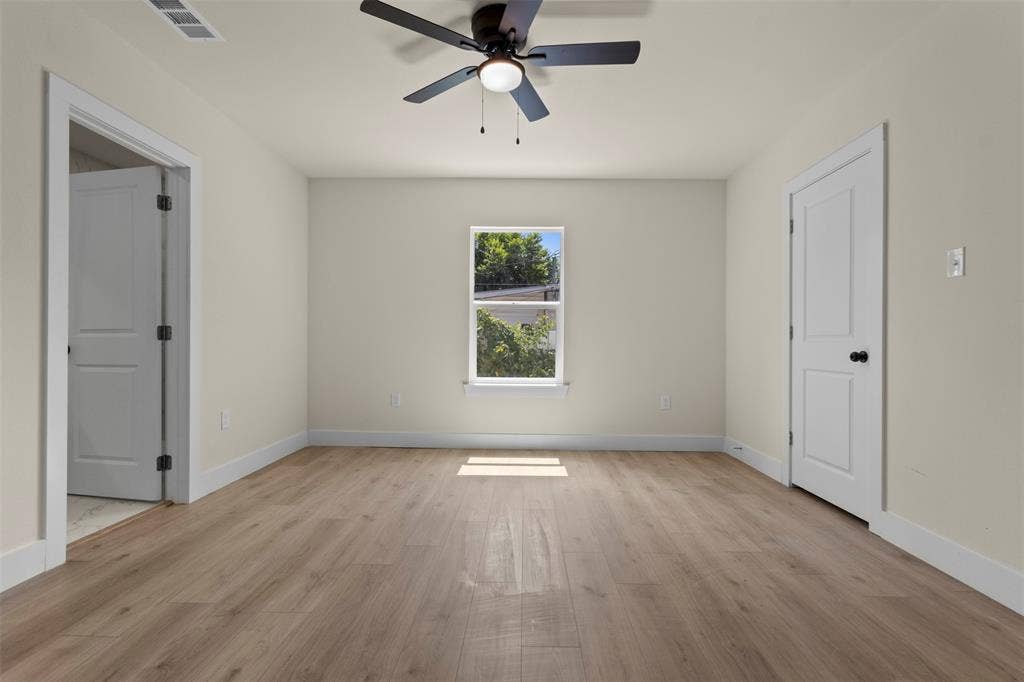 1104 S Brighton Avenue, Dallas, TX 75208 Wood-finish flooring, crisp white trim, and a ceiling fan with integrated lighting