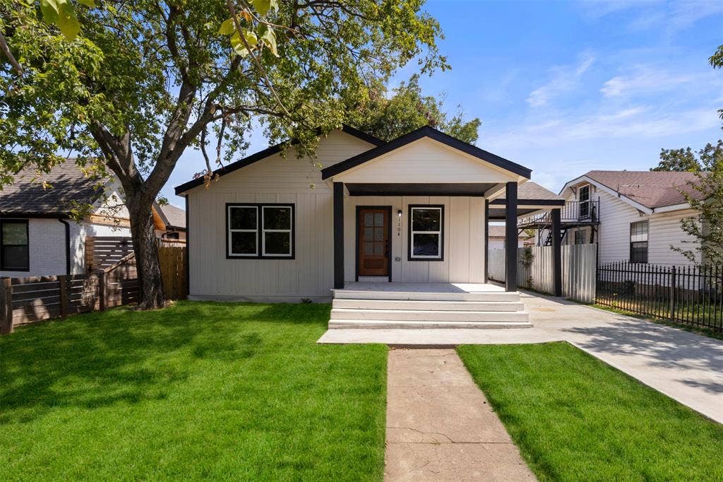 1104 S Brighton Avenue, Dallas, TX 75208 Contemporary exterior with white siding, black trim, and a wood-finish front door