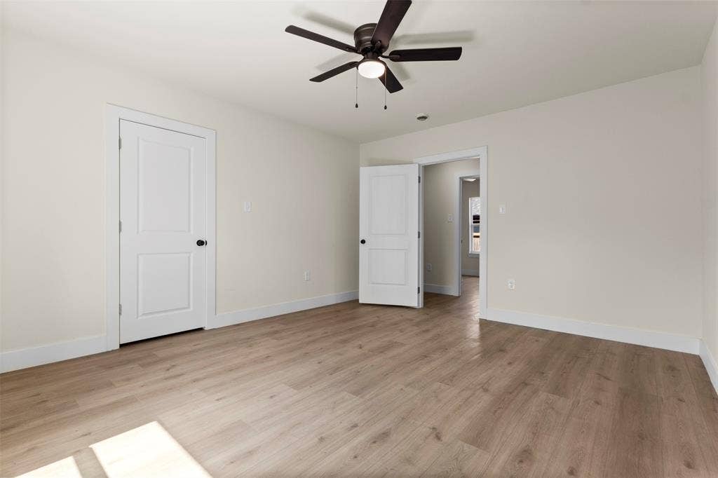 1104 S Brighton Avenue, Dallas, TX 75208 Wood-finish flooring, white trim, and a ceiling fan with light fixture