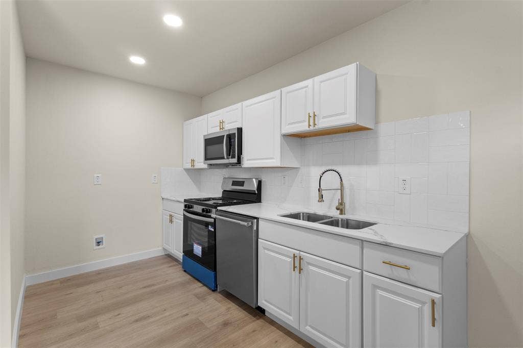 1104 S Brighton Avenue, Dallas, TX 75208 Kitchen featuring white cabinetry, stainless steel appliances, wood-finish flooring, and recessed lighting